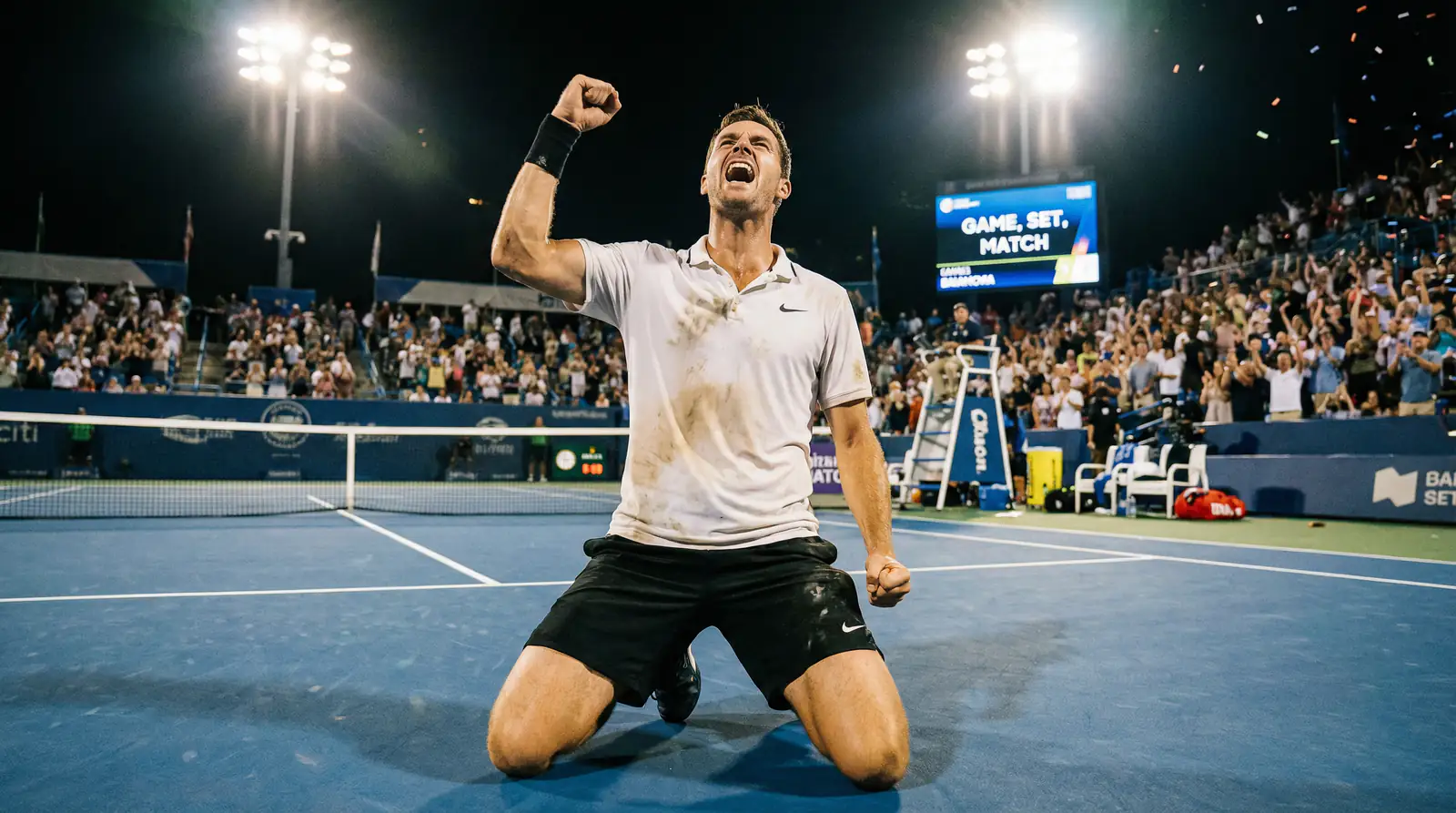 Tenista celebrando una victoria con el puño en alto en una pista de tenis