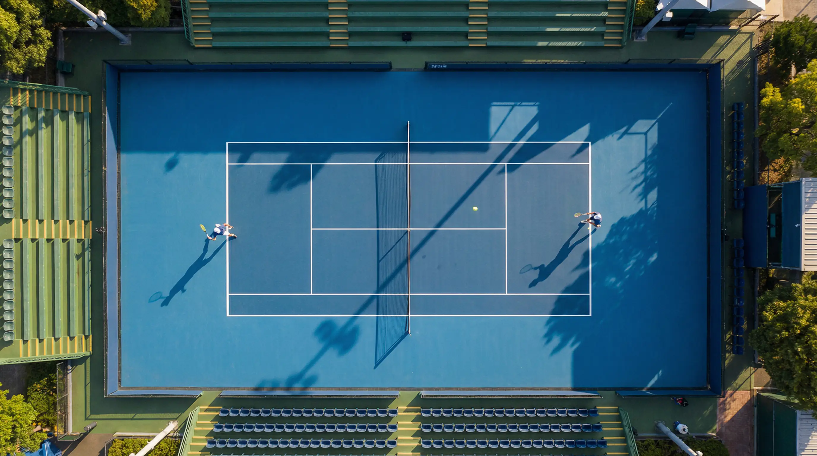 Vista cenital de una pista de tenis durante un partido profesional con dos jugadores en acción
